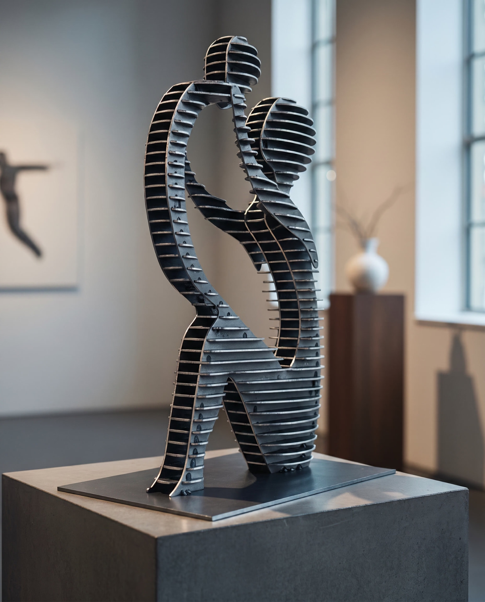 Skulptur zweier tanzender Figuren aus geschichteten Stahl-Lamellen auf einem Sockel